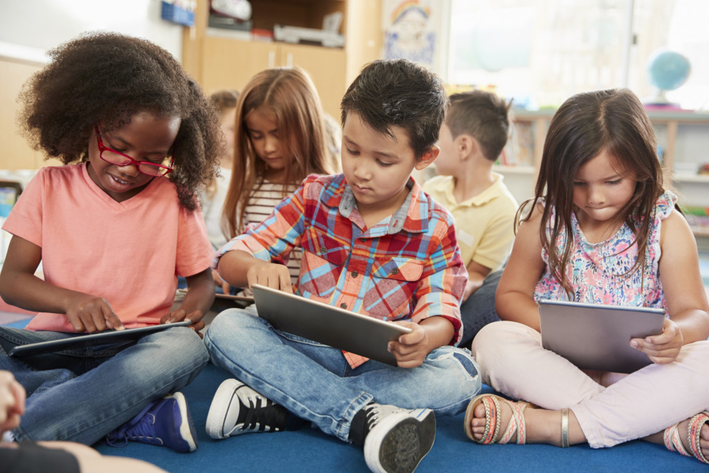 3 kids using digital tablets