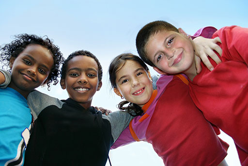 Kids smiling in a group outside