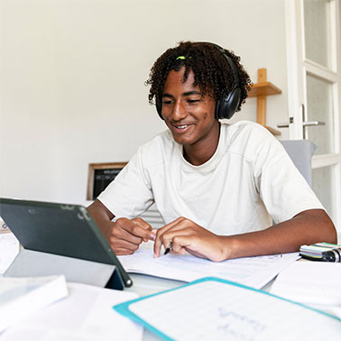 Older boy smiling at tablet